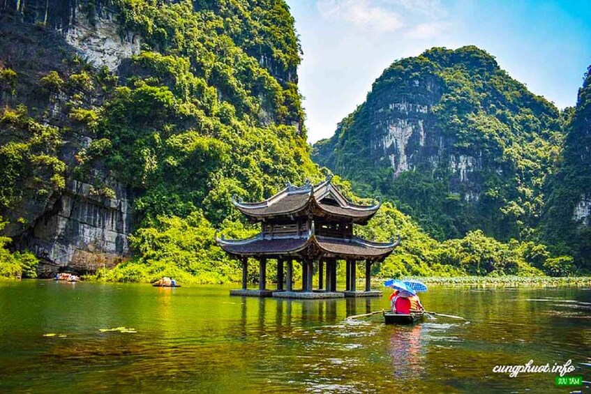 A traditional Chinese pavilion on a lake surrounded by lush greenery and cliffs. 4
