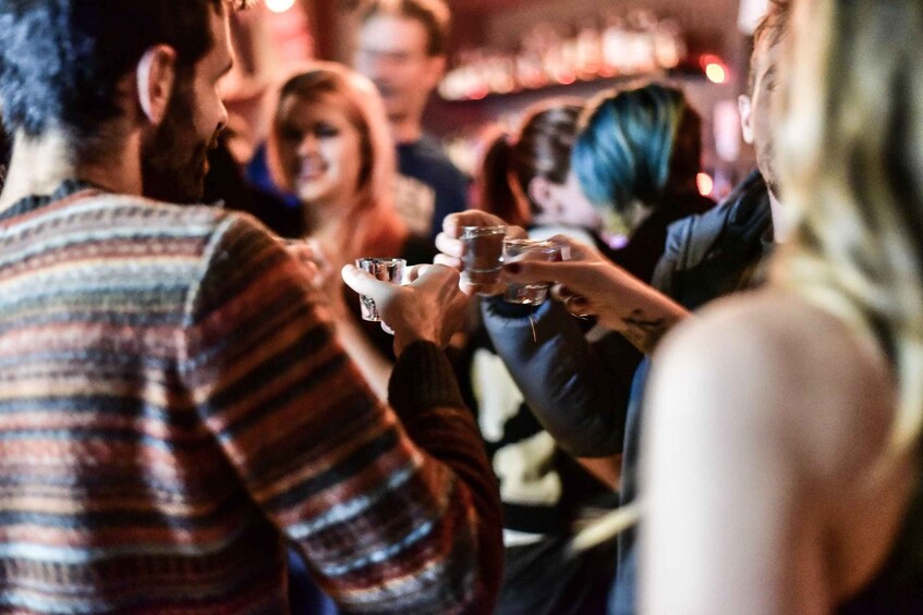 A group of people toasting with drinks in a social setting. 2