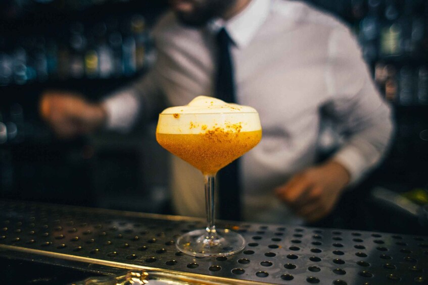 A cocktail in a stemmed glass on a bar counter. 5