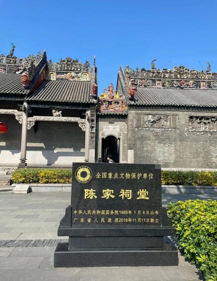 A traditional Chinese building with ornate decorations and a sign in front. 1