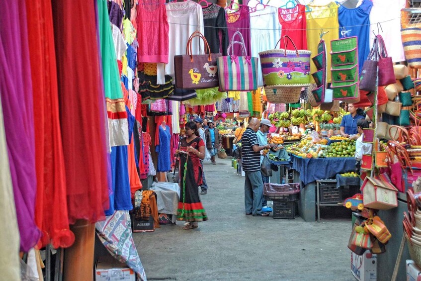 A bustling market with colorful textiles, bags, and fresh produce. 4