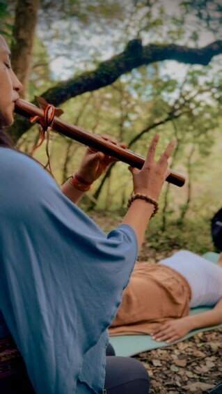 A person playing a flute outdoors. 5