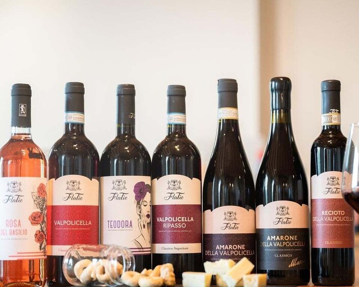 A row of wine bottles with labels indicating different varieties and names. 3