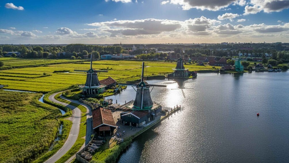 A river with windmills and a boat docked near the shore. 5