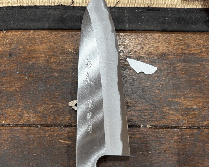 A knife with engraved text on a wooden surface. 3