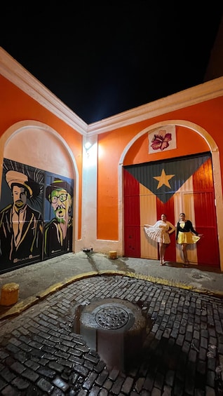 A courtyard with murals, a fountain, and a red door. 4