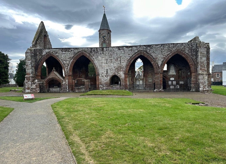 An old stone church with arched windows and a clock tower. 1