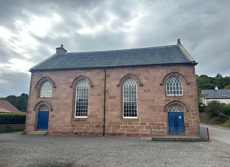 A brick church with arched windows and a slate roof. 4