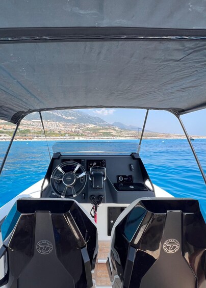 A boat's interior with a steering wheel, dashboard, and two seats. 3