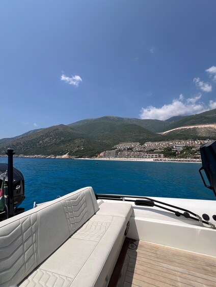 A boat's deck with a view of a coastal town and mountains in the distance. 2