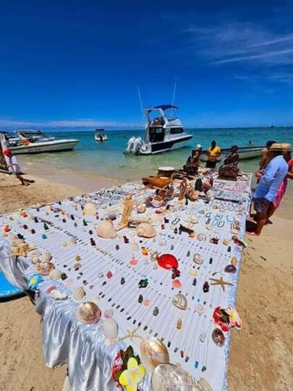 A beach market with a table displaying various seashells and trinkets. 5