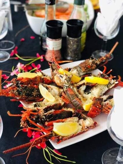 A plate of cooked crayfish garnished with lemon slices. 4