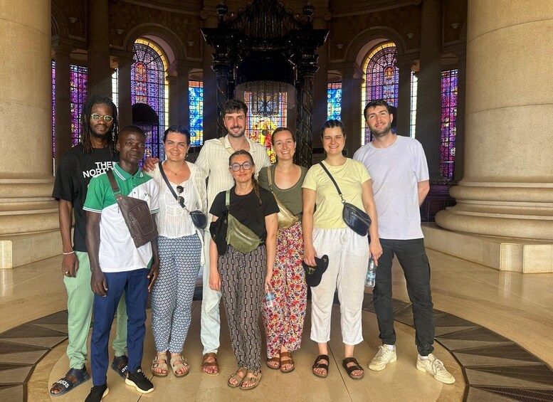 A group of people standing in a building with stained glass windows and classical architecture. 5
