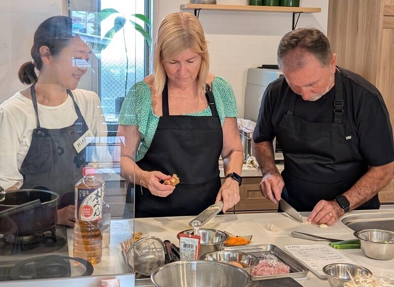 Three people preparing food in a kitchen. 3