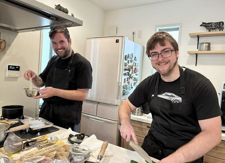 Two individuals in a kitchen, one pouring liquid into a bowl and the other holding a knife. 5