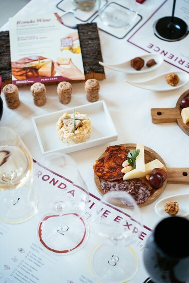 A table with various food items and wine glasses. 4