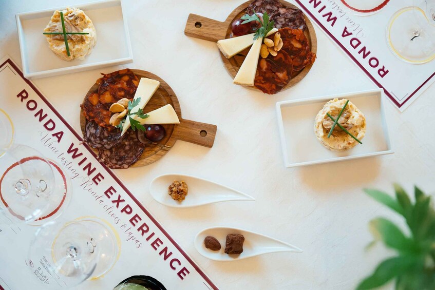 A table with various food items and a wine tasting menu. 5