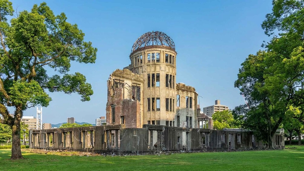 A historic building with a dome and columns, surrounded by trees and grassy area. 2