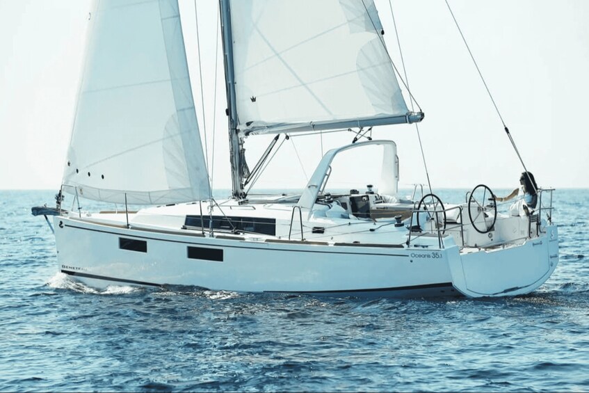 A white sailboat with two sails, named 'Oceani 35,' on the water. 1