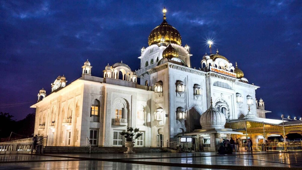 A grand, illuminated building with domes and intricate architecture at night. 2