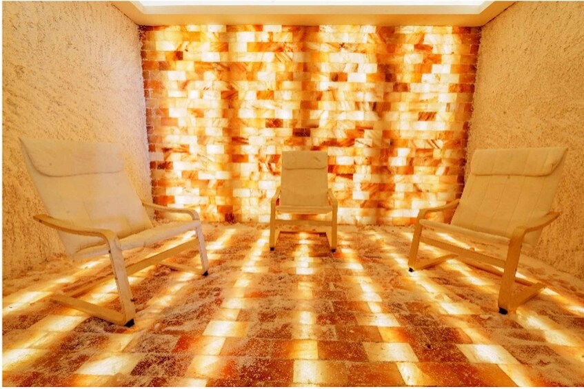 A room with a patterned wall and two chairs. 5