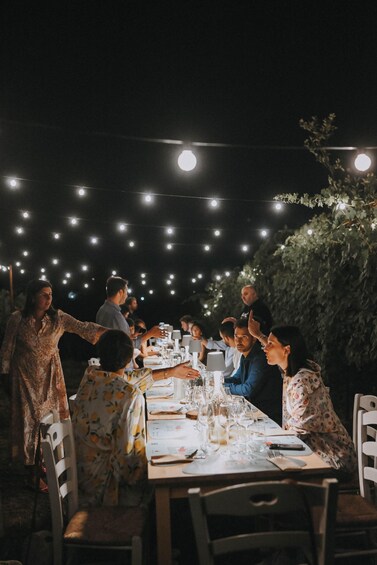 An outdoor dining area with string lights, tables set with plates, glasses, and cutlery. 4