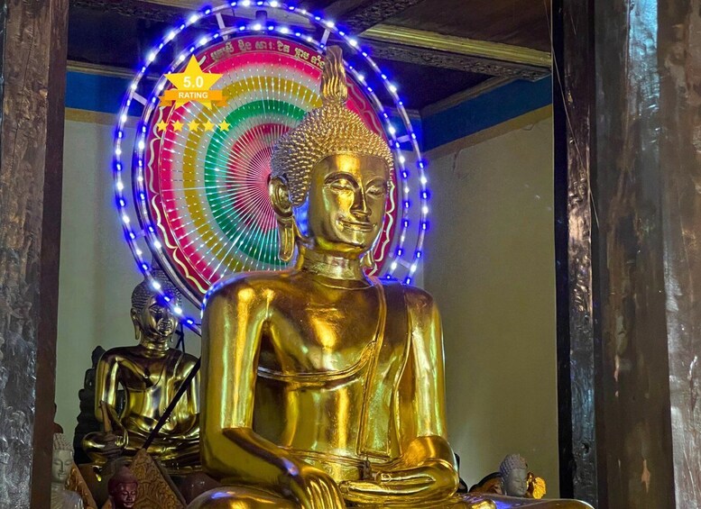 A golden Buddha statue with a colorful LED halo and a rating sign. 5
