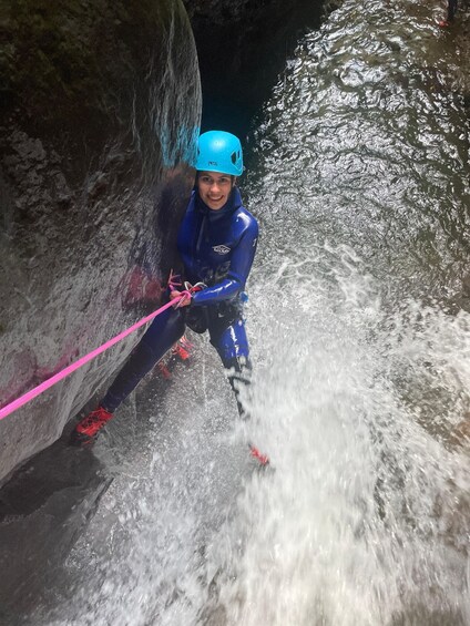 A person rappelling down a rocky watercourse. 2