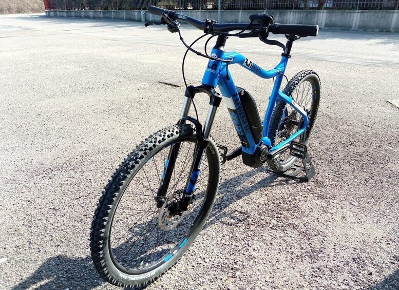A blue mountain bike with a front suspension fork, black tires, and a water bottle attached to the frame. 2