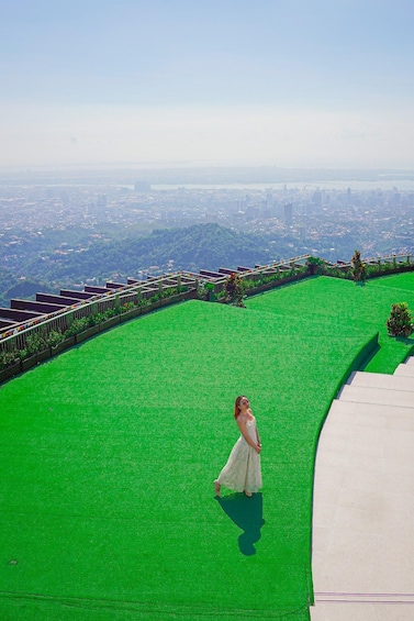 A person walking on a green carpet with a cityscape in the background. 5