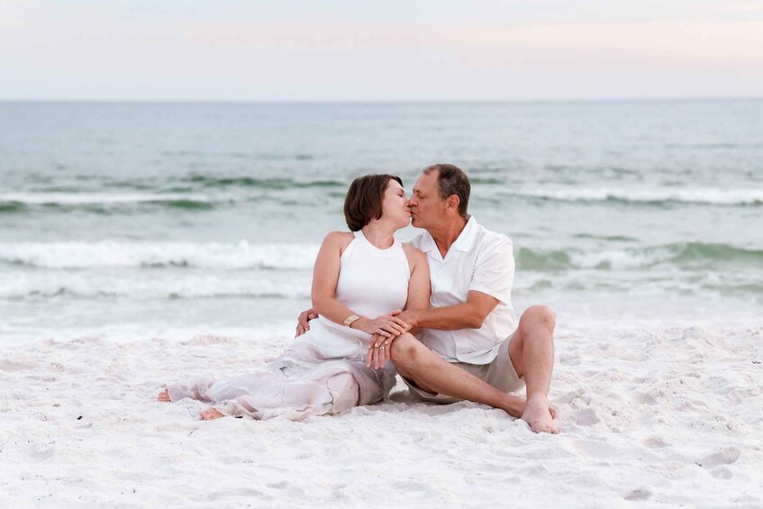 A couple sitting on a beach with the ocean in the background. 5
