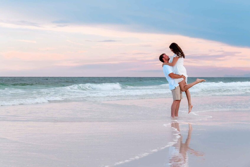 A couple on a beach with the ocean in the background. 2