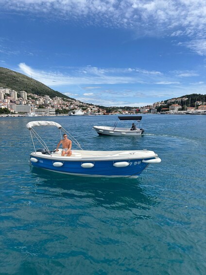 A calm harbor with boats, a clear blue sky, and a cityscape in the background. 2