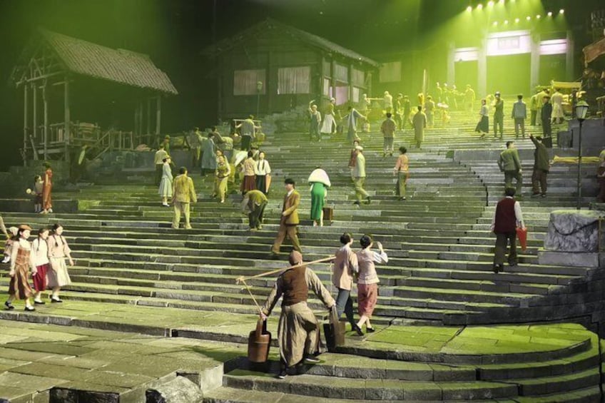 A group of people ascending a set of stone steps in a historical setting with traditional buildings in the background. 5