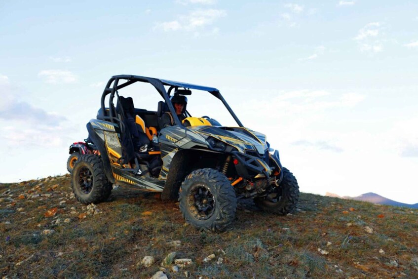 A four-wheeled off-road vehicle on a rocky terrain with a clear sky. 3