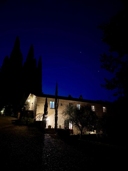 A stone building at night with illuminated windows and a clear sky. 5
