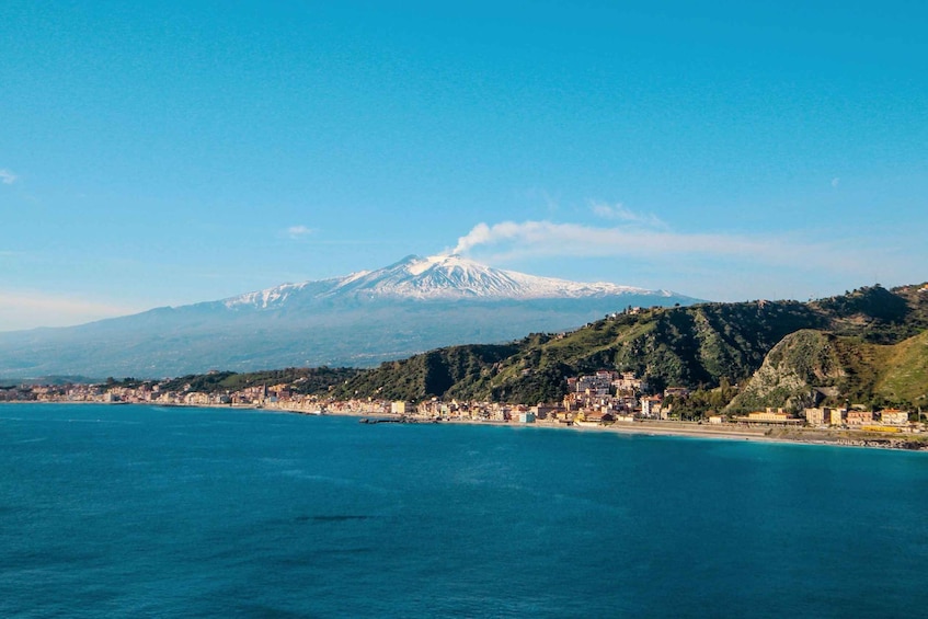 A coastal town with a snow-capped mountain in the background. 2