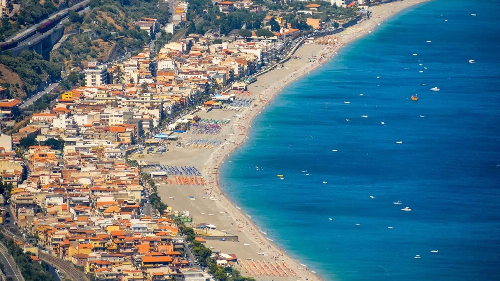 A coastal town with a beach, boats, and a highway. 3