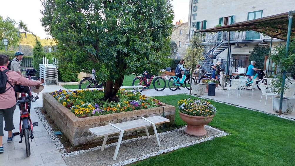 A garden with flowers, a bench, and bicycles. 3
