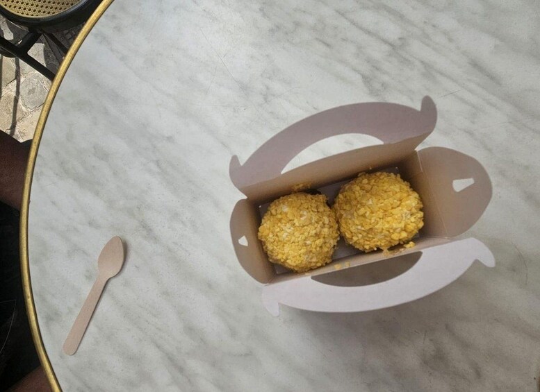 A cardboard box with two round, golden-brown items on a marble surface. 3