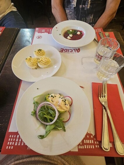 A table with two plates of food, a glass of water, and cutlery. 5