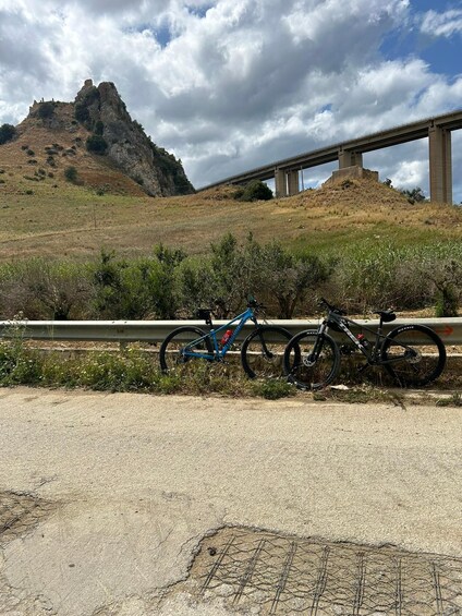 A mountain, a bridge, and two bicycles parked by the roadside. 5