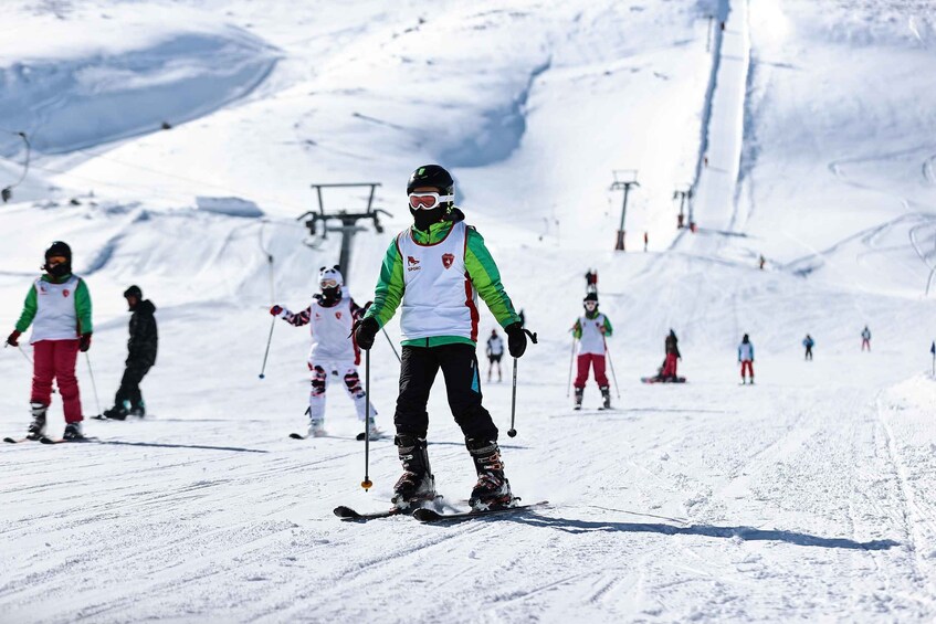 Skiers on a snowy slope with ski lifts in the background. 3