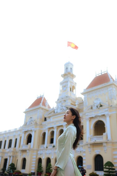A person flying a kite in front of a historic building with ornate architecture. 1