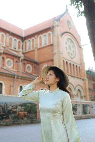 A person in traditional attire standing in front of a historic building with arched windows and a clock tower. 2