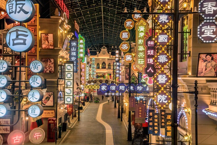 A brightly lit indoor market with illuminated signs and a central walkway. 2