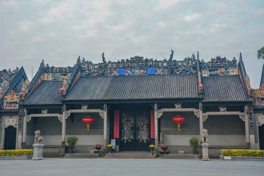 A traditional Chinese building with ornate roofs, red lanterns, and stone lion statues. 5