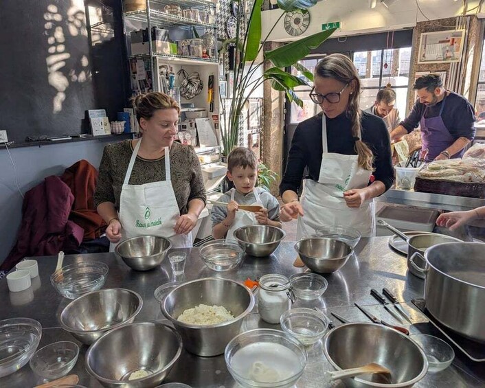 A cooking class with participants preparing food in a kitchen. 1