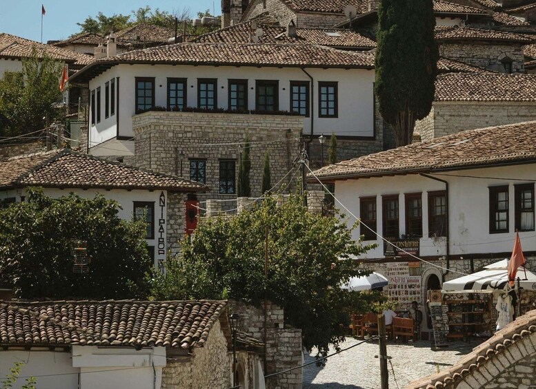 A traditional stone building with a tiled roof, surrounded by other similar structures. 2