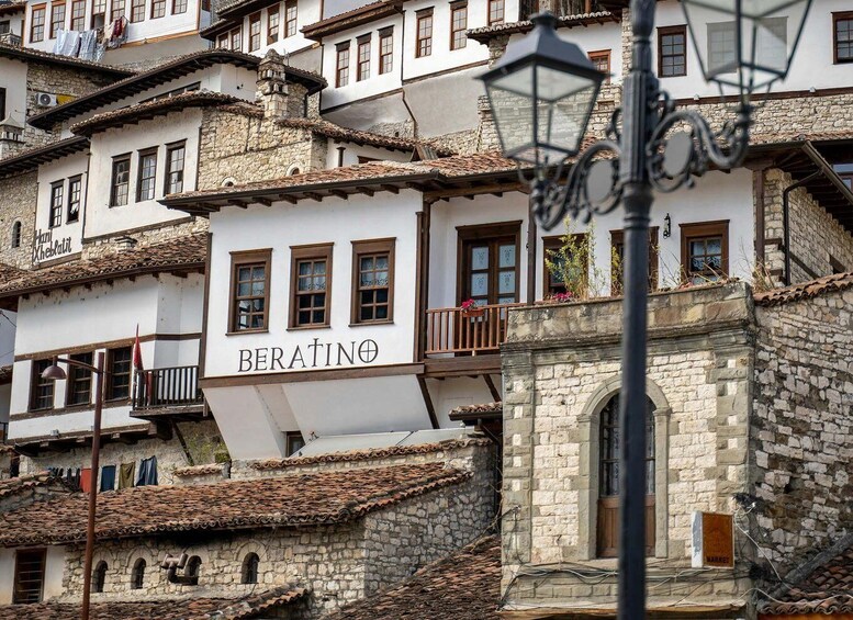 A traditional building with the sign 'BERATINO' and a stone wall. 4